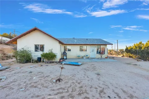 a view of a house with backyard and a tree