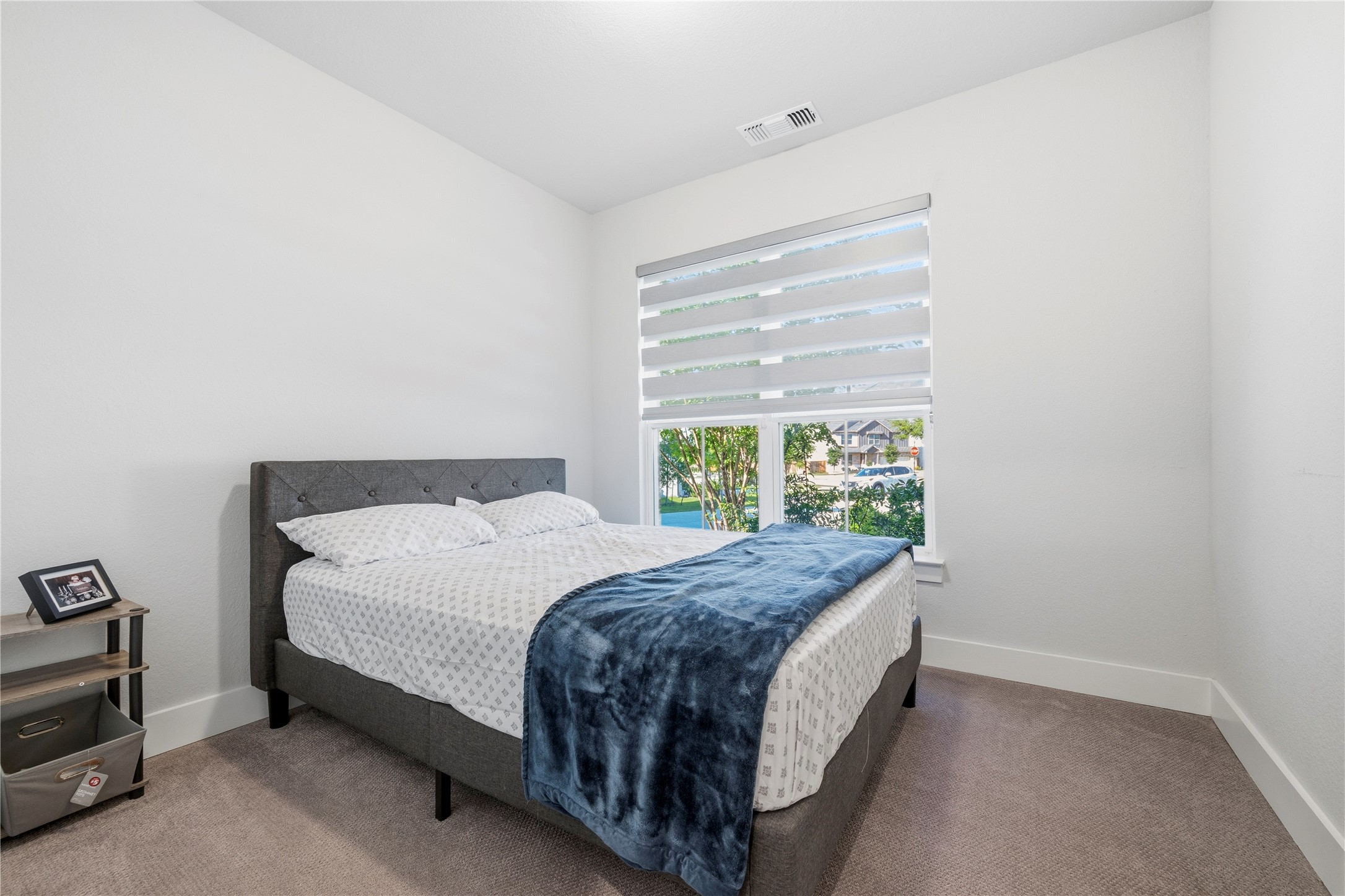 105 Autumn Oak Way Georgetown, TX 78628 - Photo 5 of 40 Bedroom featuring a large window with privacy blinds, plush carpet flooring, white painted walls, and crisp white baseboards