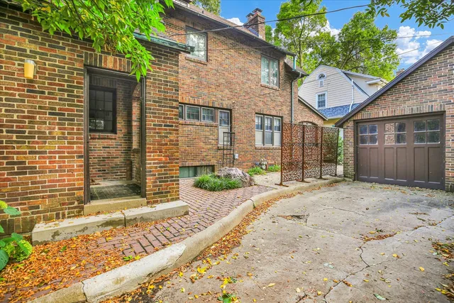 a view of a house with a yard and large tree