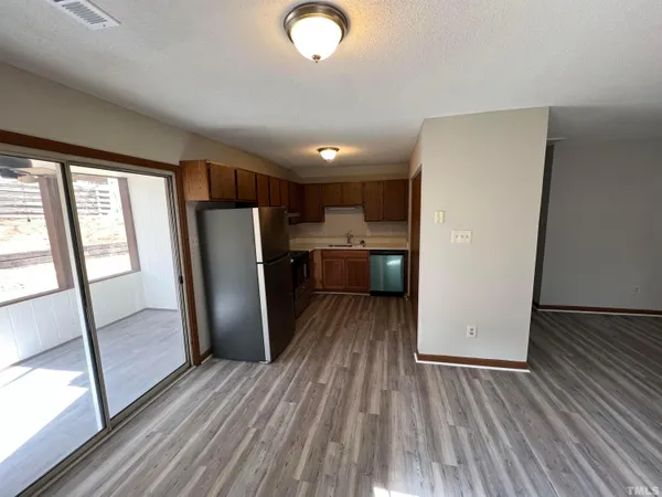 a view of kitchen with refrigerator stove and wooden floor