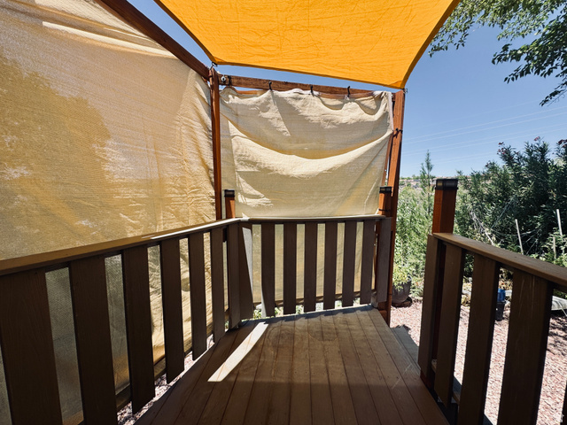 150 North 3050 East, Unit 4 St. George, UT 84790 - Photo 23 of 24 Wood-finish decking with coordinating railings, shaded by a light-colored fabric canopy and side panels