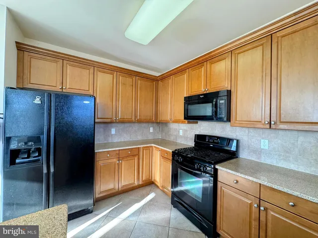a kitchen with stainless steel appliances granite countertop a refrigerator stove and sink