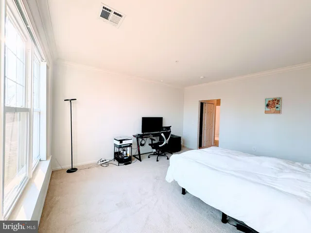 a bedroom with furniture a bed and a flat tv screen