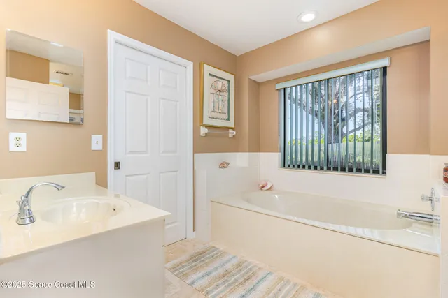 a bathroom with a tub sink and a window