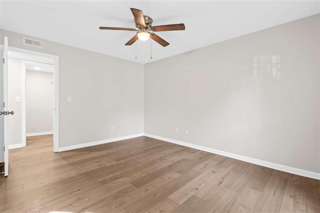 1166 Booth Road, Unit 407 Marietta, GA 30008 - Photo 13 of 18 an empty room with wooden floor and ceiling fan