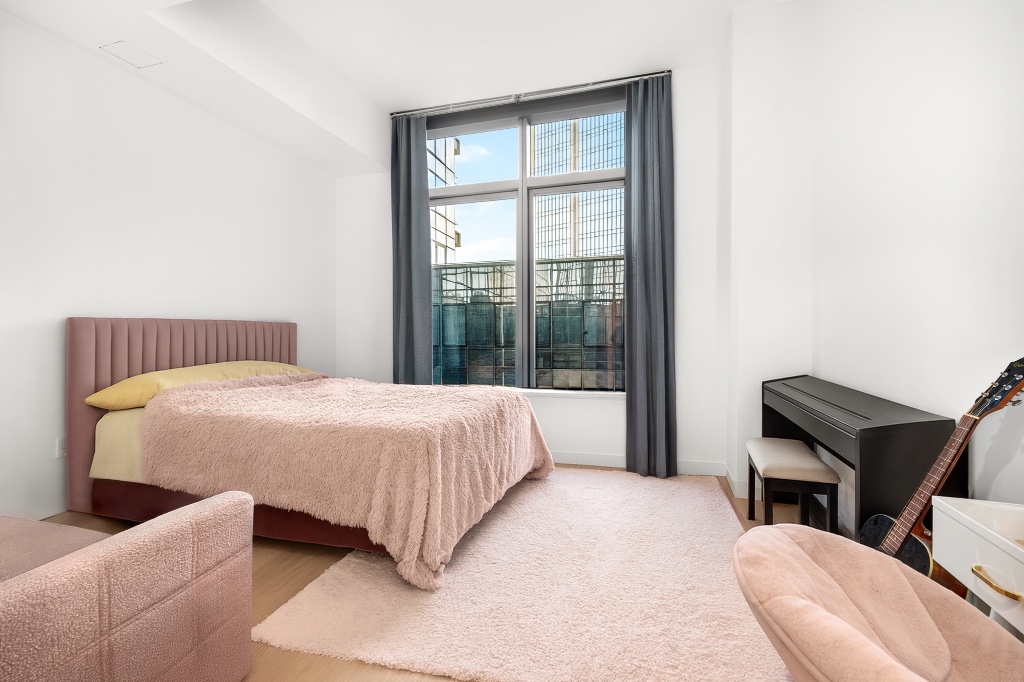 3 Court Square, Unit 621 Queens, NY 11101 - Photo 1 of 13 a bedroom with a bed and a chair