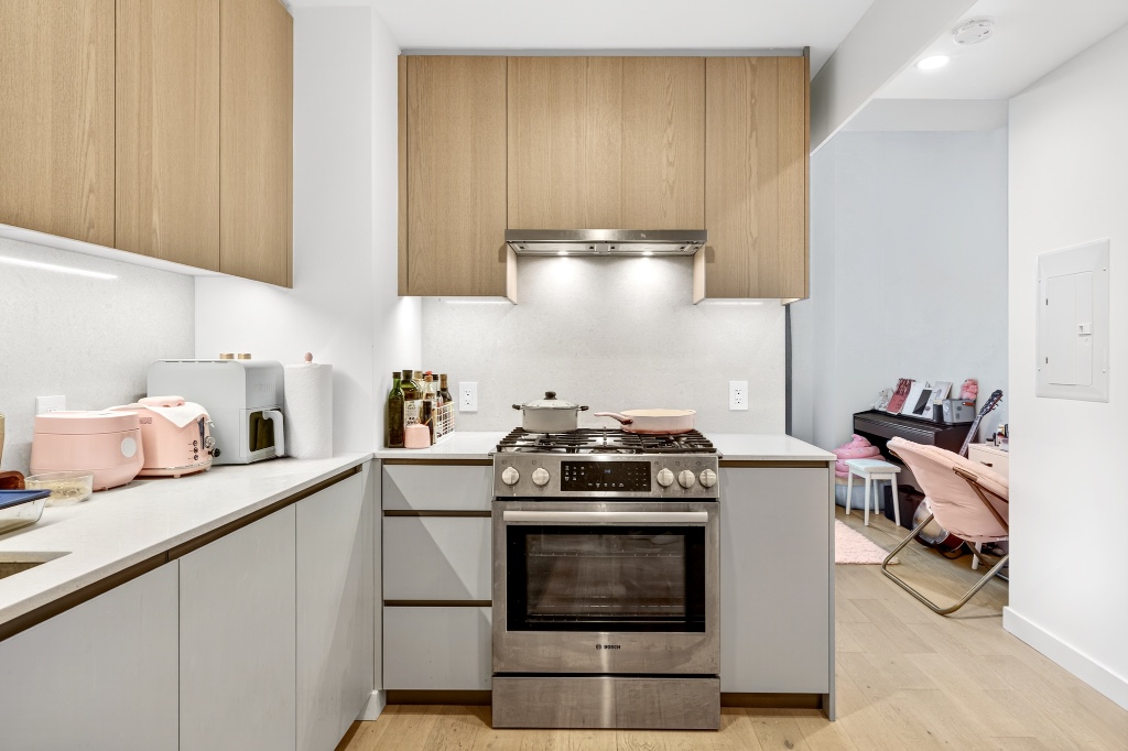 3 Court Square, Unit 621 Queens, NY 11101 - Photo 4 of 13 a kitchen with stainless steel appliances a stove a sink and a refrigerator