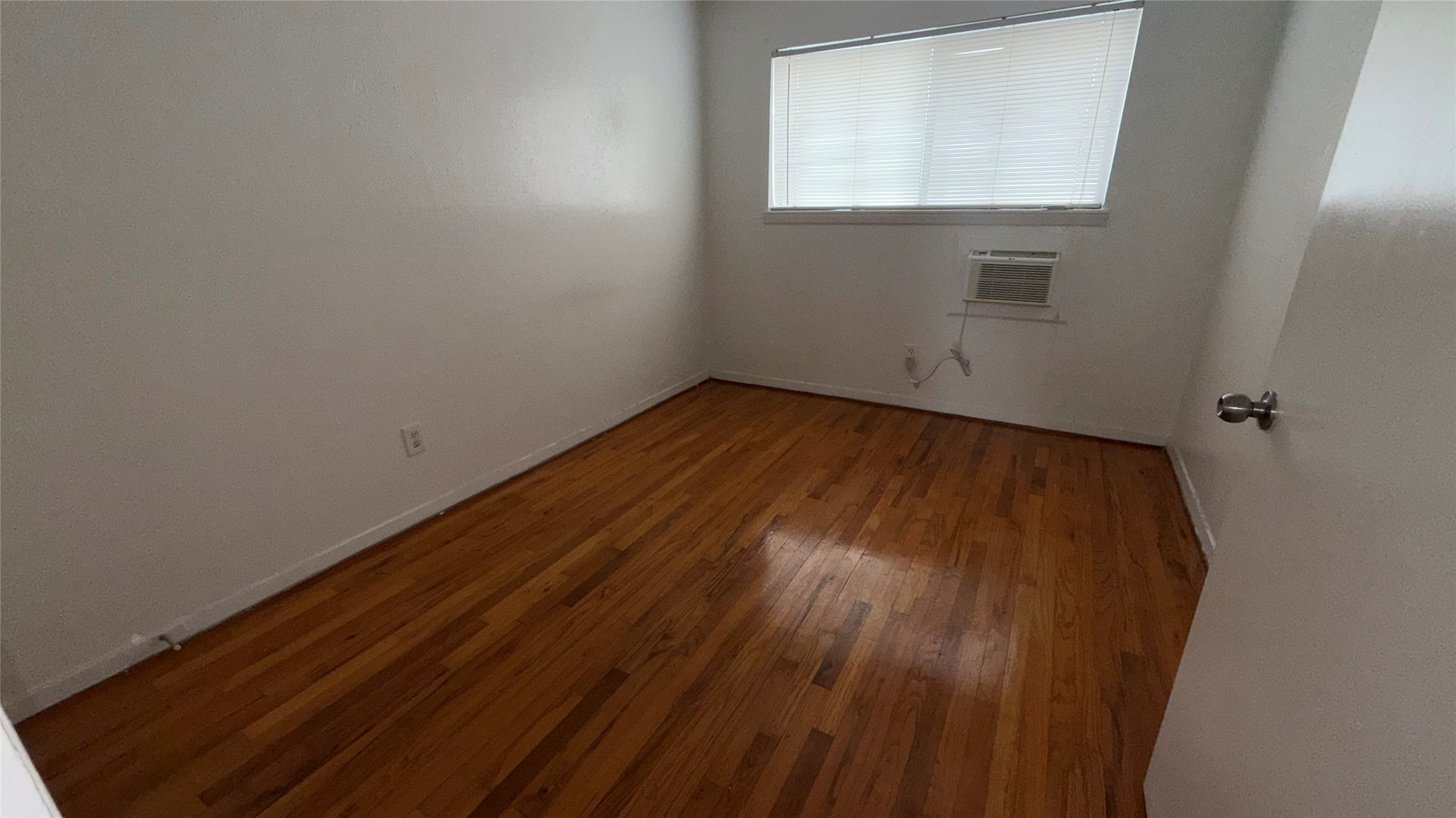4921 Crawford Street, Unit 9 Houston, TX 77004 - Photo 5 of 9 an empty room with wooden floor and windows