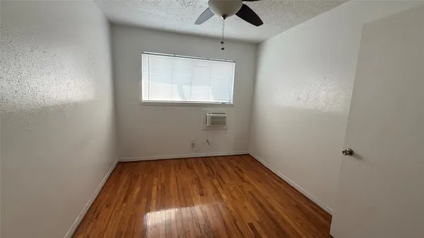 an empty room with a window and a ceiling fan