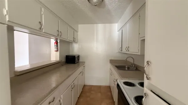 a kitchen with stainless steel appliances a sink a stove a refrigerator and a window