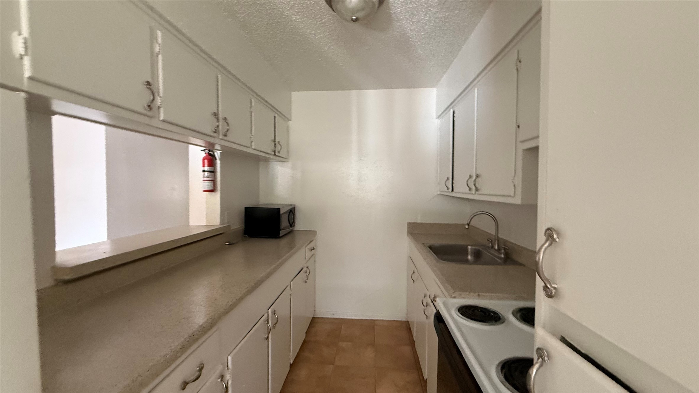 4921 Crawford Street, Unit 9 Houston, TX 77004 - Photo 9 of 9 a kitchen with stainless steel appliances a sink a stove a refrigerator and a window