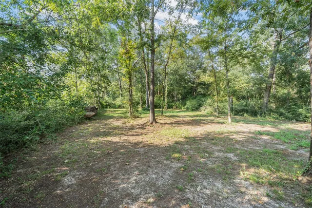 an aerial view of residential house with outdoor space and trees all around