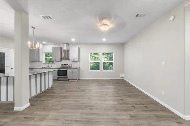 an open kitchen with a refrigerator and microwave