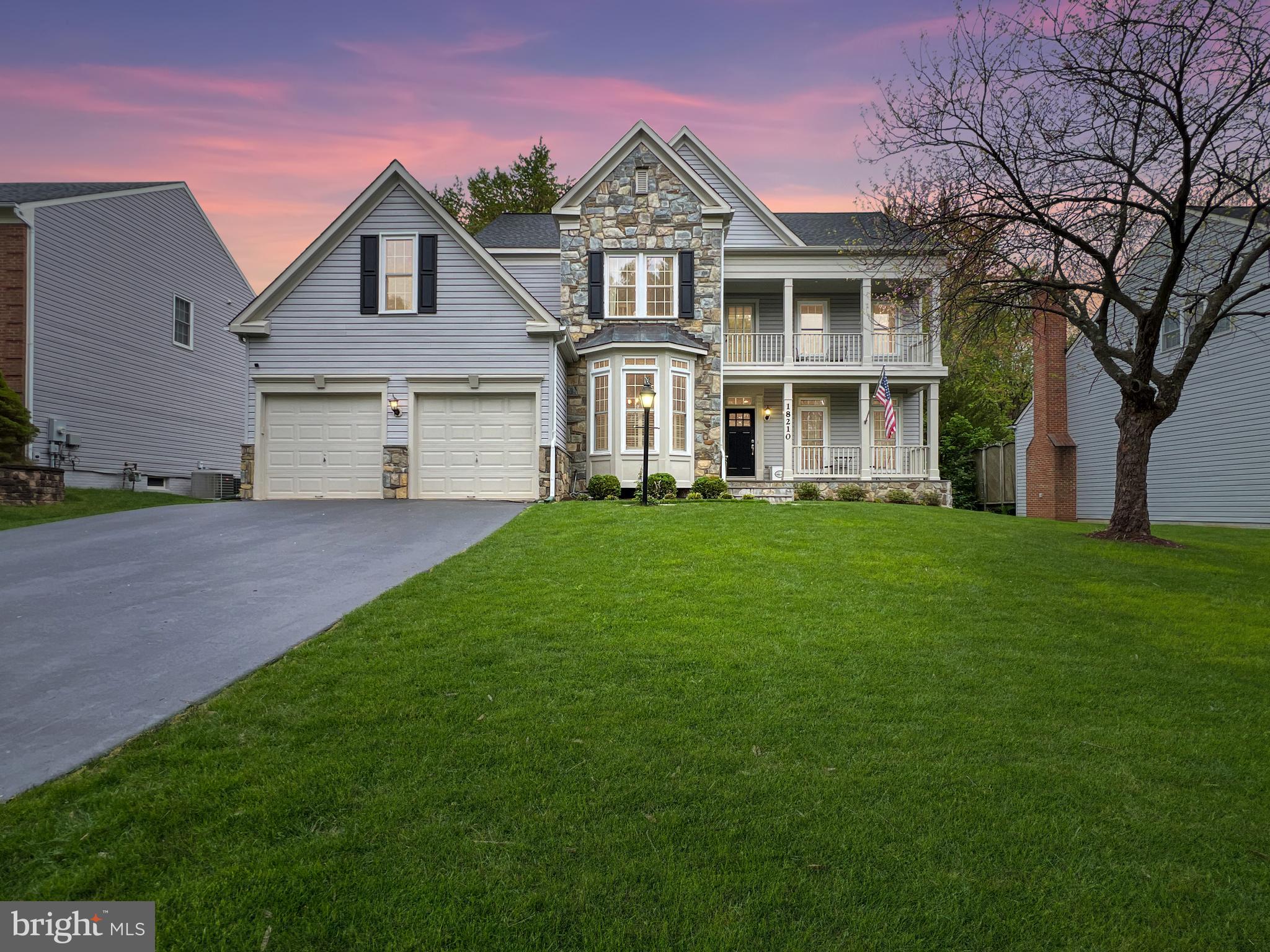 a front view of a house with a garden and trees