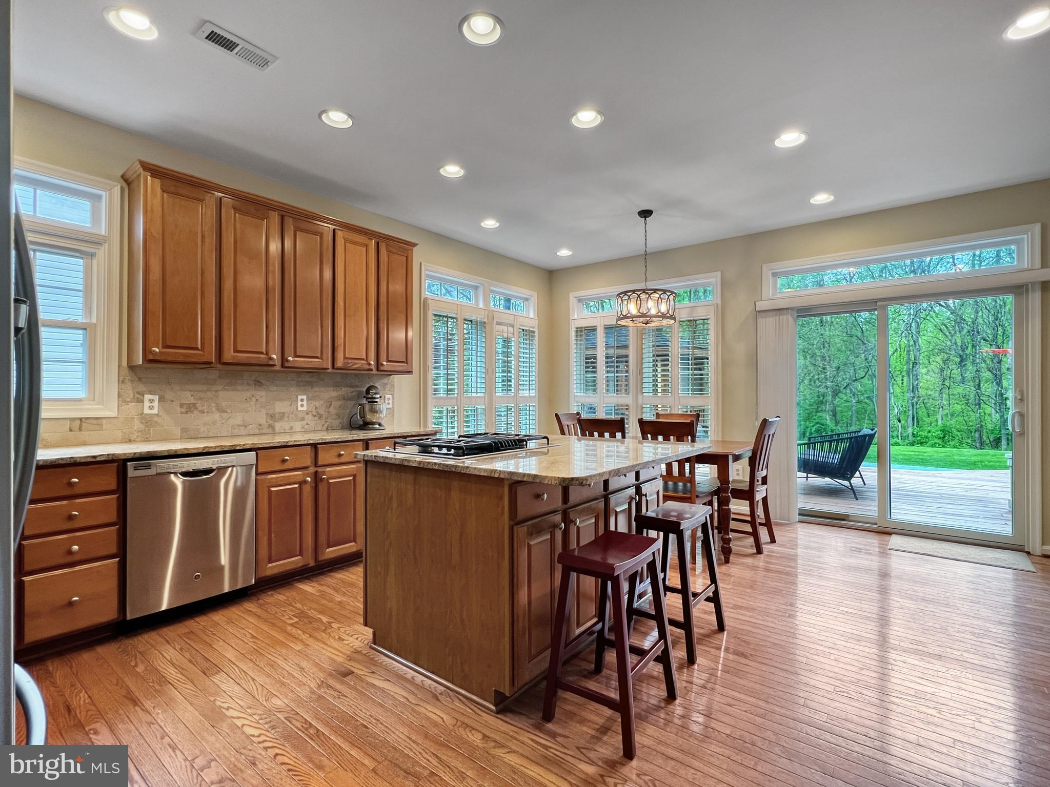 18210 Wickham Road Olney, MD 20832 - Photo 11 of 74 a large kitchen with lots of counter space dining table and stainless steel appliances