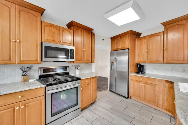 a kitchen with granite countertop a refrigerator stove and microwave