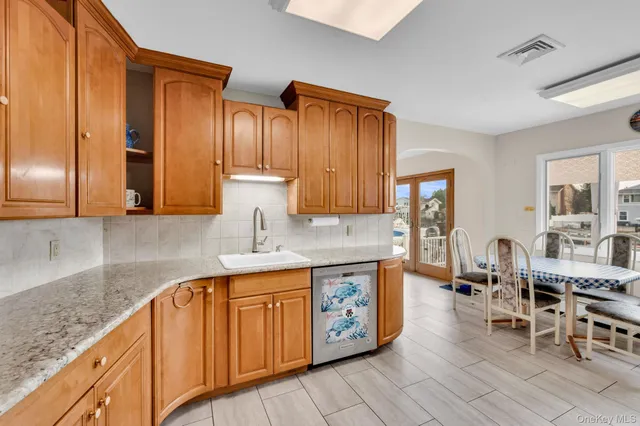 a kitchen with stainless steel appliances granite countertop a sink dishwasher stove and cabinets with wooden floor