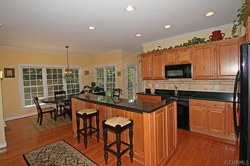13336 Tipple Point Road Midlothian, VA 23114 - Photo 24 of 24 a kitchen with stainless steel appliances granite countertop a stove top oven a sink dishwasher a dining table and chairs with wooden floor