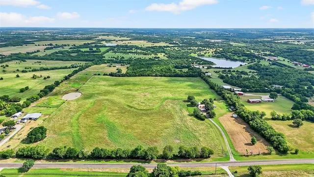 an aerial view of residential houses with outdoor space and trees