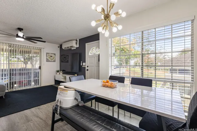 a view of a dining room with furniture a chandelier and wooden floor