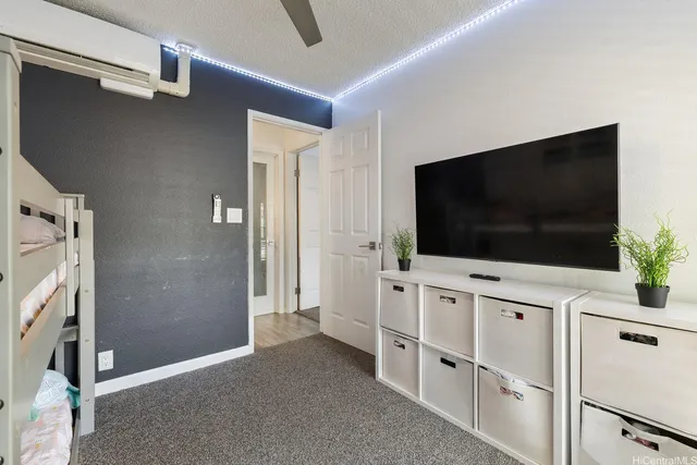 a living room with flat screen tv and floor to ceiling window
