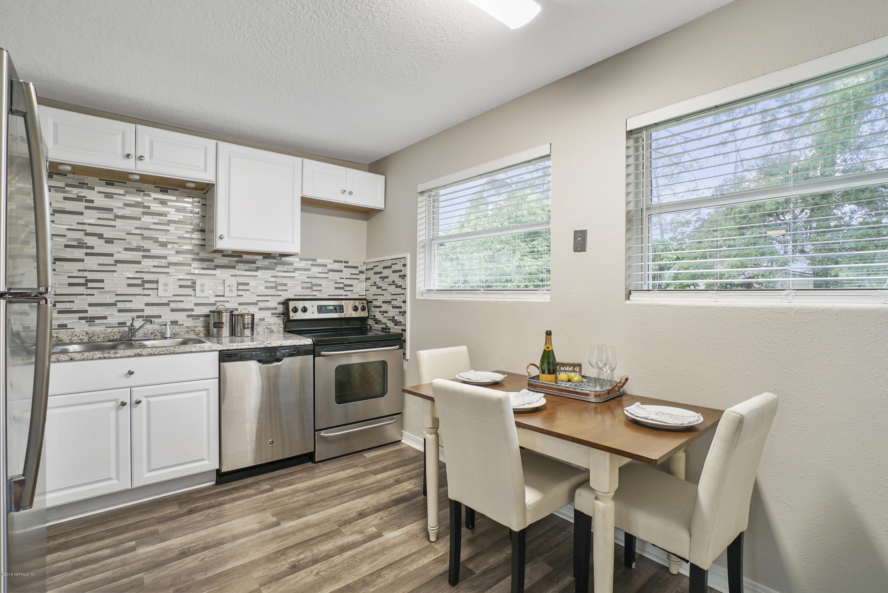 10506 Briarcliff Road South Jacksonville, FL 32218 - Photo 3 of 14 a kitchen with a stove a sink a refrigerator dining table and chairs