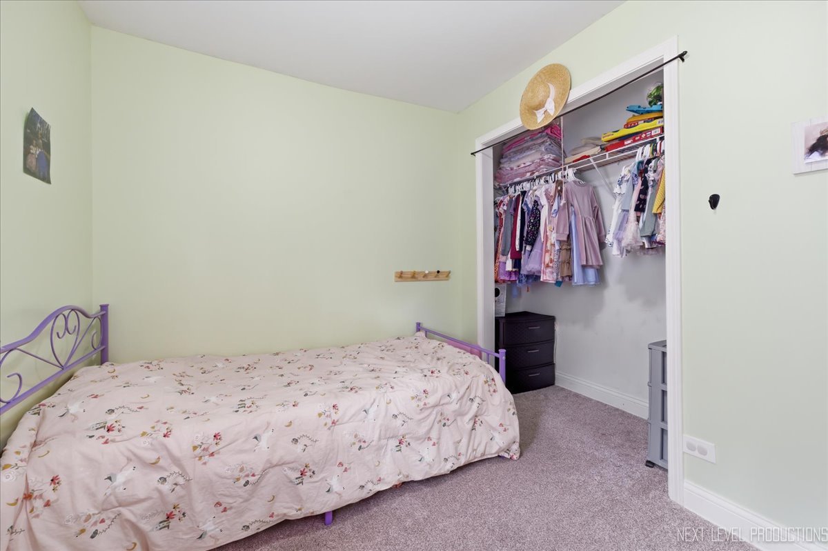 138 North Calhoun Street Aurora, IL 60505 - Photo 15 of 24 a bedroom with a bed and a lamp on dresser