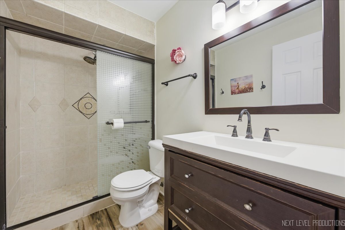 138 North Calhoun Street Aurora, IL 60505 - Photo 16 of 24 a bathroom with a sink a toilet a shower and a mirror