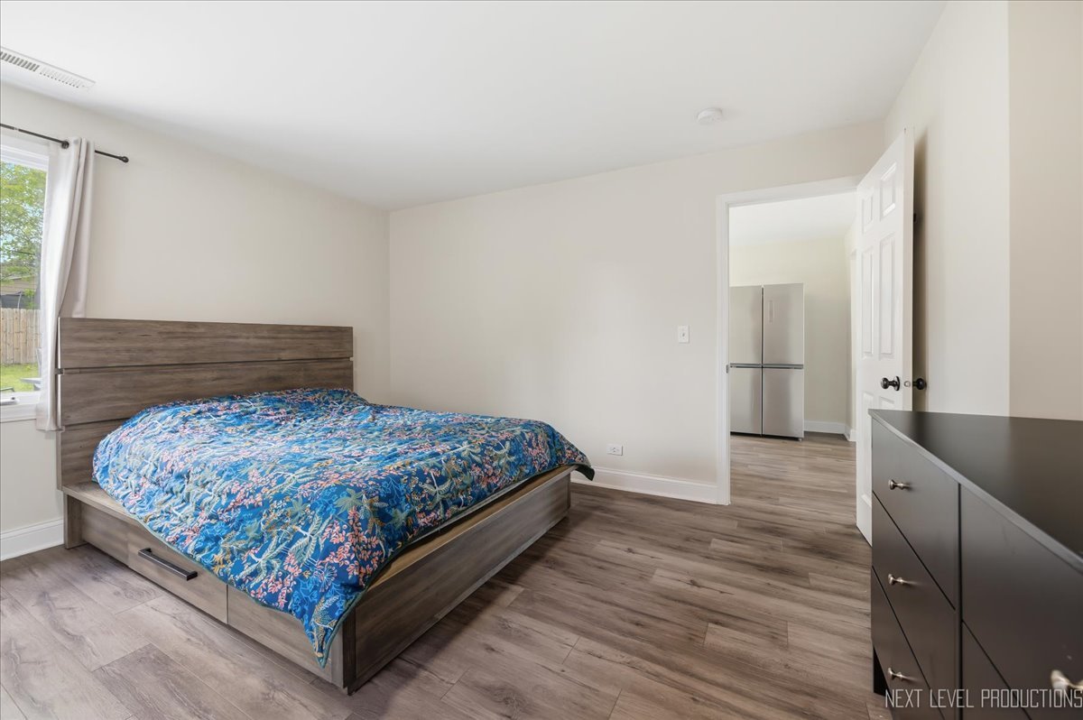 138 North Calhoun Street Aurora, IL 60505 - Photo 18 of 24 a bedroom with a bed and wooden floor