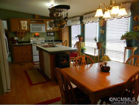 592 Scoggins Road Rutherfordton, NC 28139 - Photo 17 of 22 a kitchen with a table chairs and flat screen tv