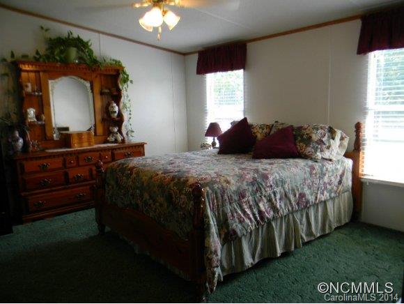 592 Scoggins Road Rutherfordton, NC 28139 - Photo 19 of 22 a bedroom with a bed a dresser and mirror