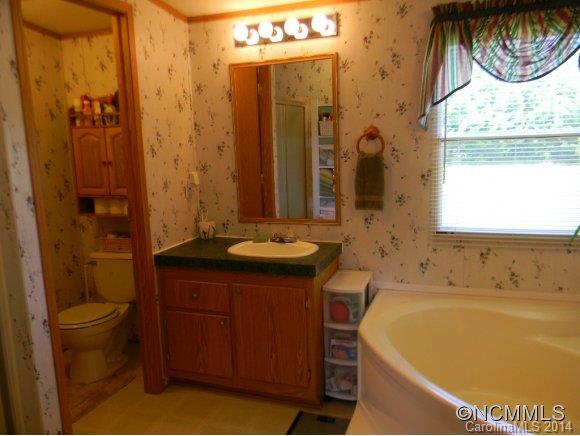 592 Scoggins Road Rutherfordton, NC 28139 - Photo 21 of 22 a bathroom with a tub sink and mirror