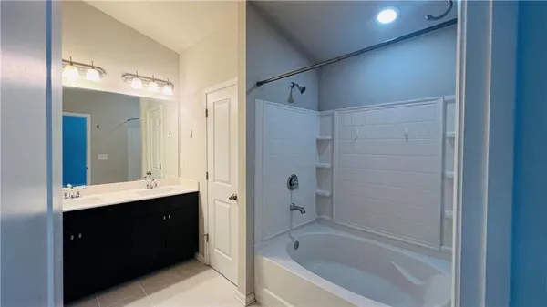 a bathroom with a bathtub shower sink vanity and a mirror