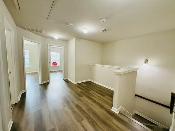 a view of hallway with stairs and wooden floor