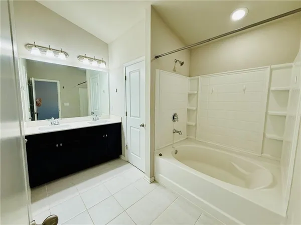 a spacious bathroom with a bathtub sink vanity and mirror