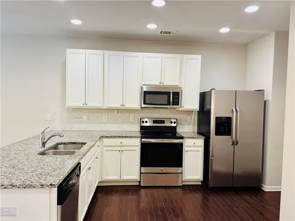 a kitchen with a sink microwave and refrigerator