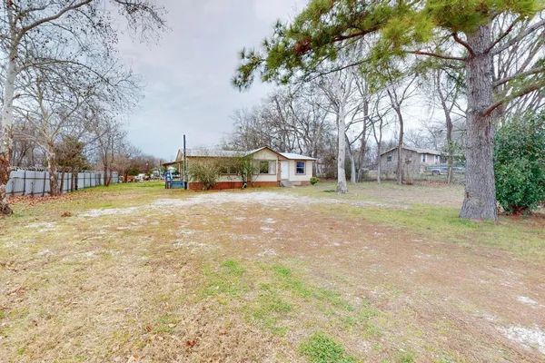 a view of a yard with a house and large trees