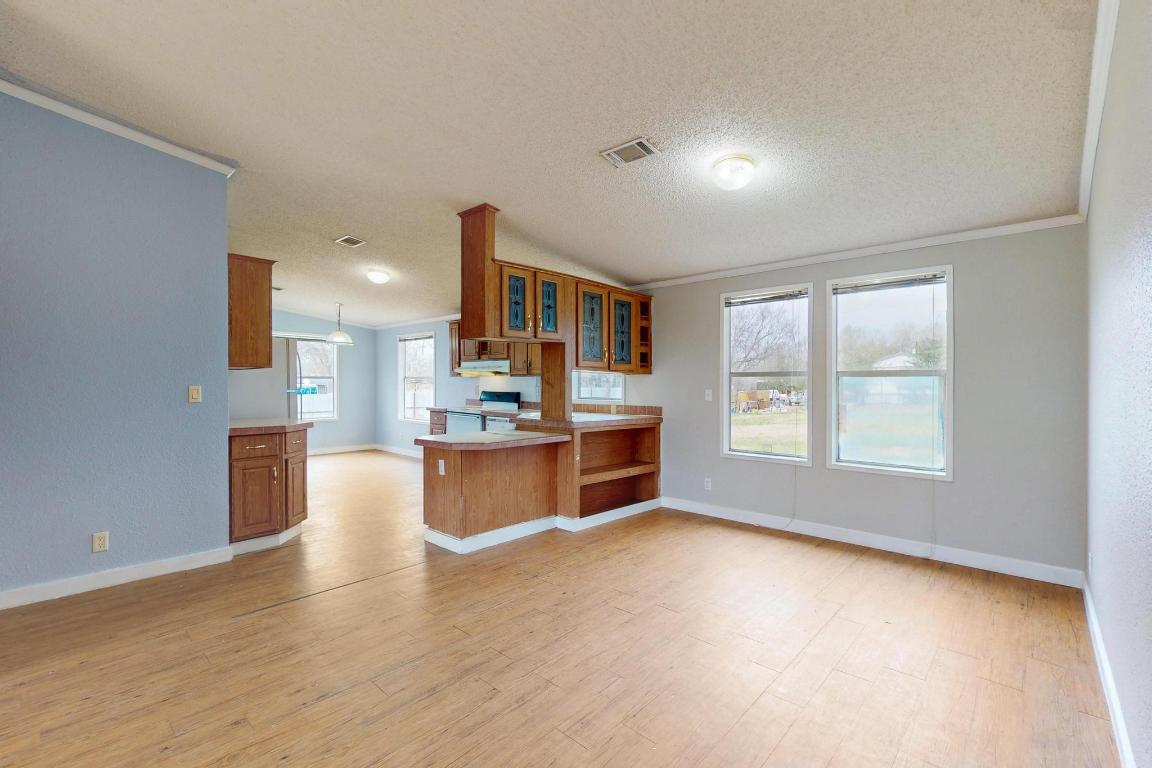 262 Highway 290 Highway East Elgin, TX 78621 - Photo 12 of 37 a open kitchen with kitchen island a sink dishwasher a stove and a refrigerator with wooden floor