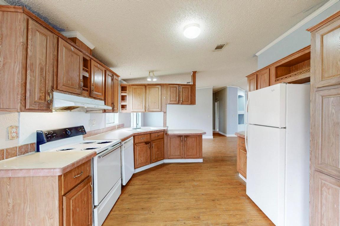 262 Highway 290 Highway East Elgin, TX 78621 - Photo 14 of 37 a kitchen with stainless steel appliances granite countertop a refrigerator a stove top oven a sink and dishwasher