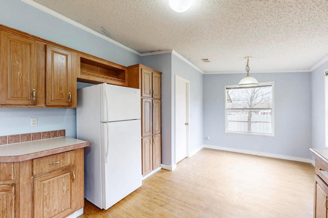 262 Highway 290 Highway East Elgin, TX 78621 - Photo 26 of 37 a kitchen with a refrigerator a stove top oven a sink and dishwasher with wooden floor
