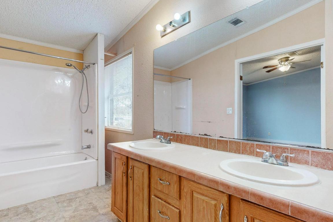 262 Highway 290 Highway East Elgin, TX 78621 - Photo 7 of 37 a bathroom with a granite countertop sink mirror and a bath tub