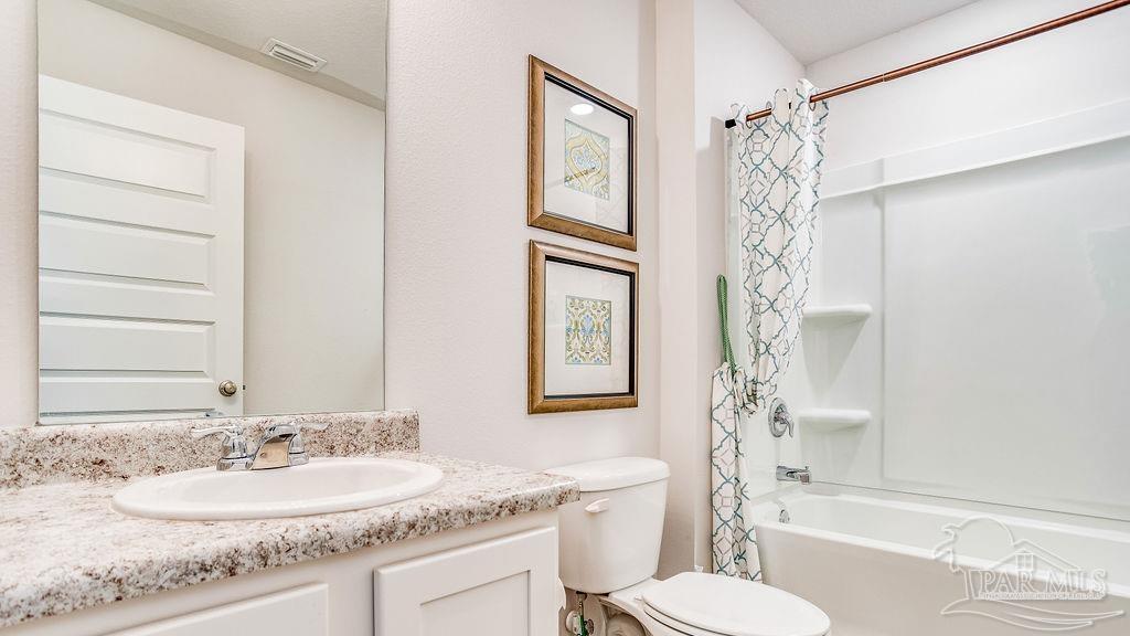 5078 Rainwater Road Milton, FL 32583 - Photo 19 of 26 a bathroom with a granite countertop sink toilet and shower