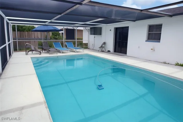 a view of a patio with a table and chairs under an umbrella