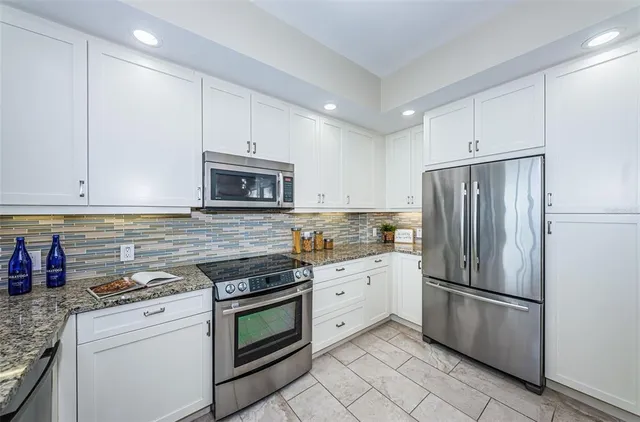 a kitchen with white cabinets and stainless steel appliances