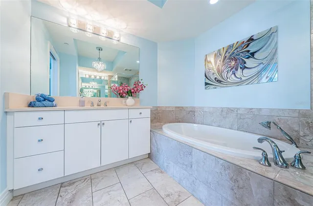 a spacious bathroom with a tub sink and mirror