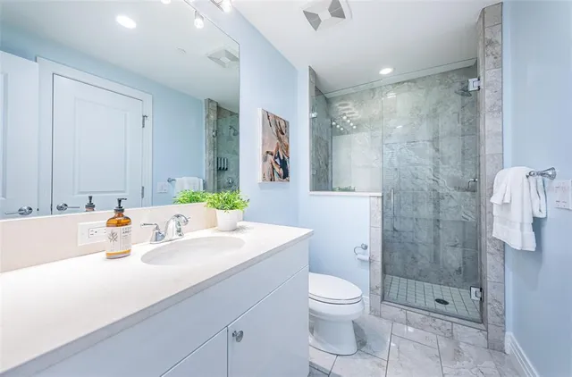 a bathroom with a sink a toilet and shower