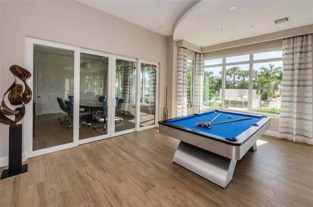 a room with pool table and glass windows