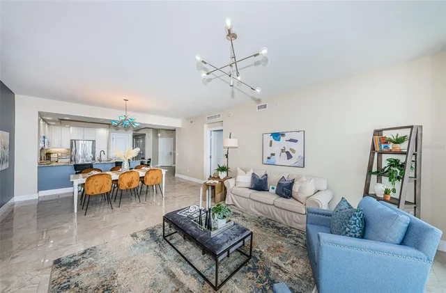 a living room with furniture a chandelier and a window