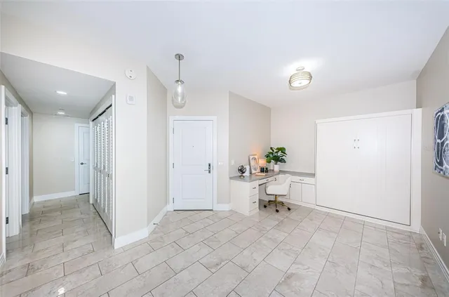 a view of a hallway to a livingroom with furniture and a window
