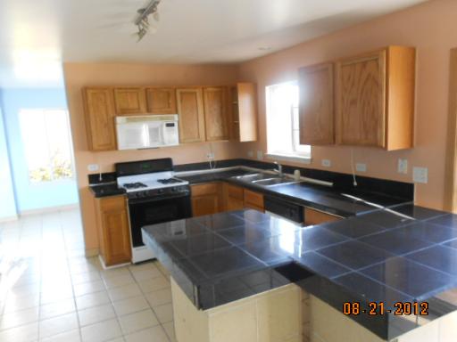 109 Fayette Court Minooka, IL 60447 - Photo 6 of 9 a kitchen with granite countertop a stove a sink and a microwave